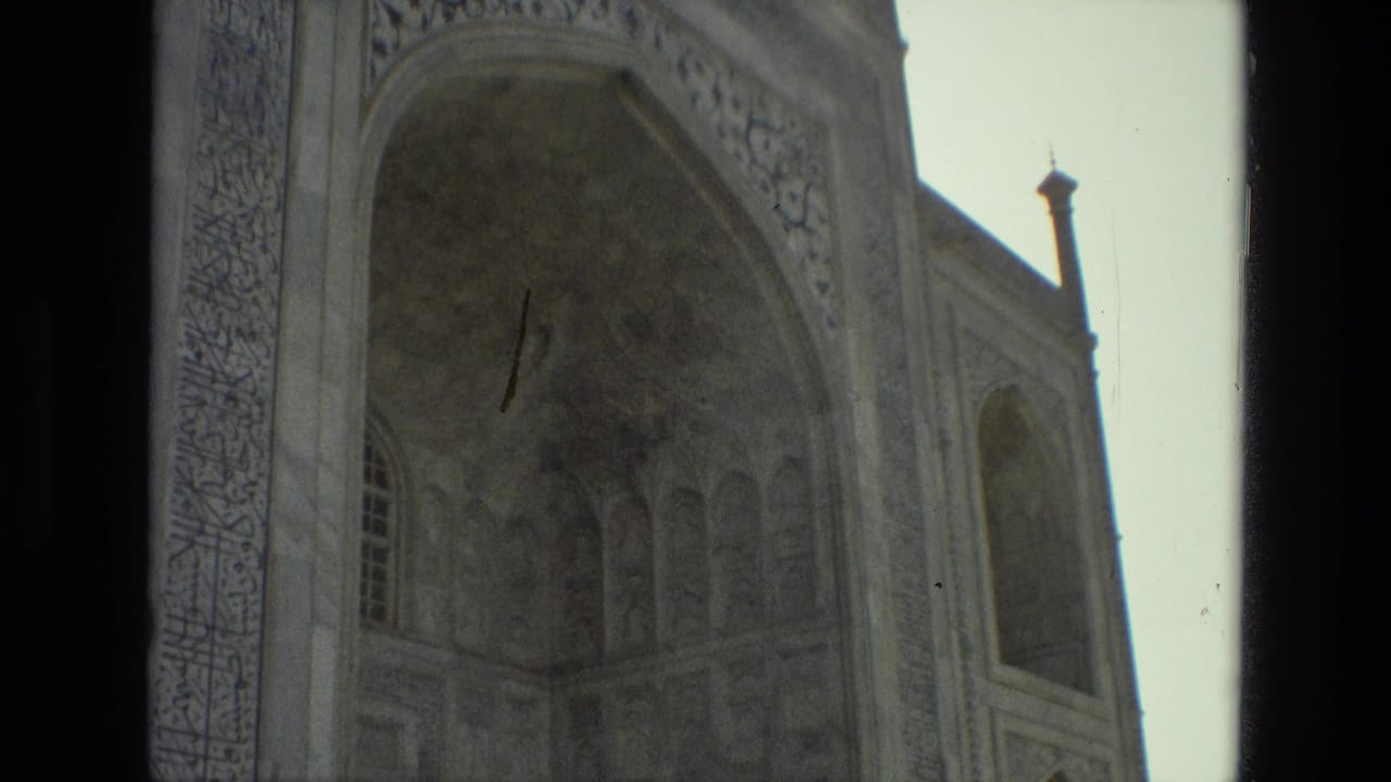 Ornate arched stone facade seen through a dark vertical frame.