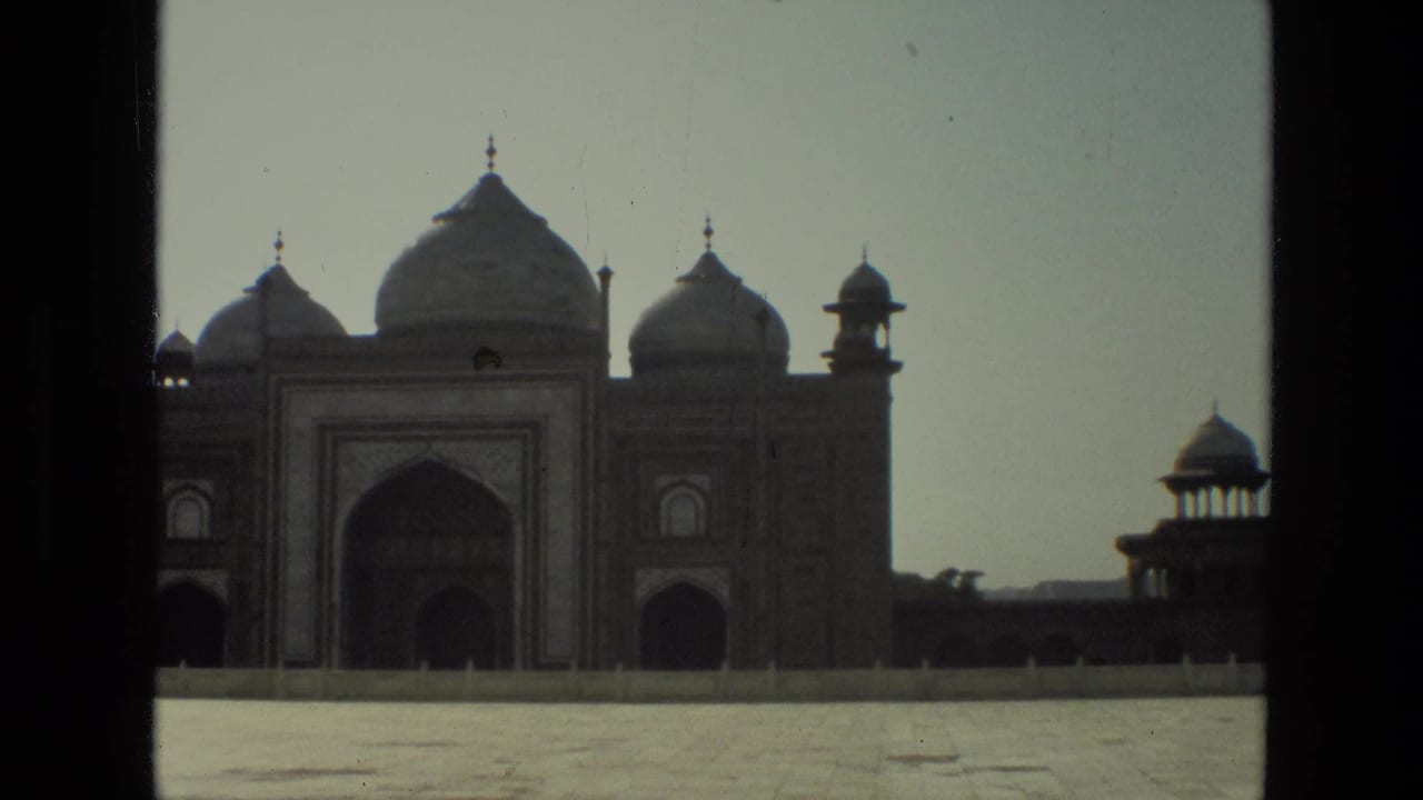 Frontal view of the Taj Mahal mosque-side building with domes and arched entrance.