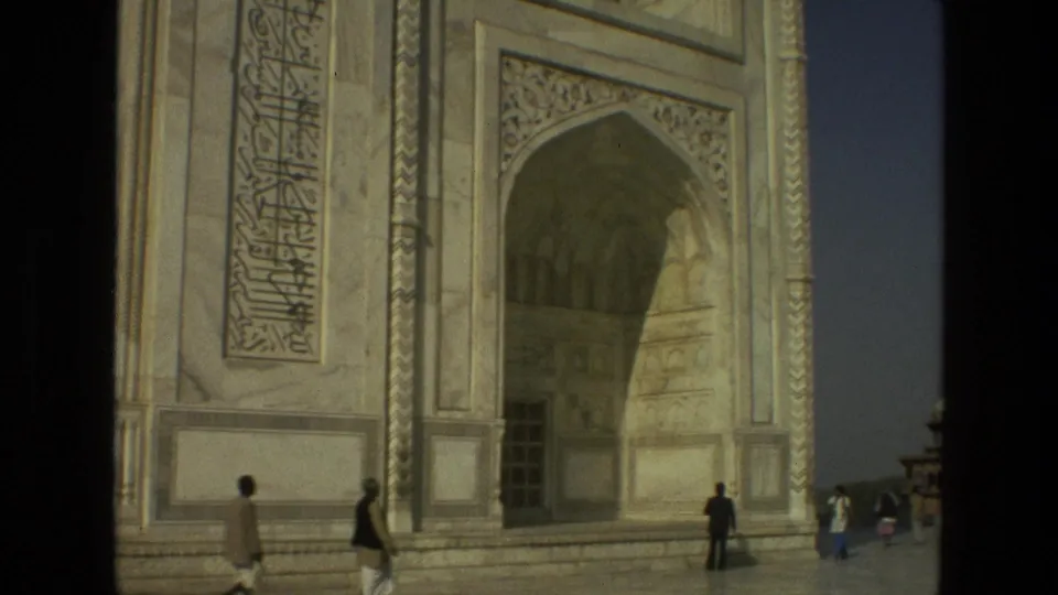 Closer 1974 8mm view of the Taj Mahal facade, with calligraphy panels, the recessed arch, and visitors walking at the base.