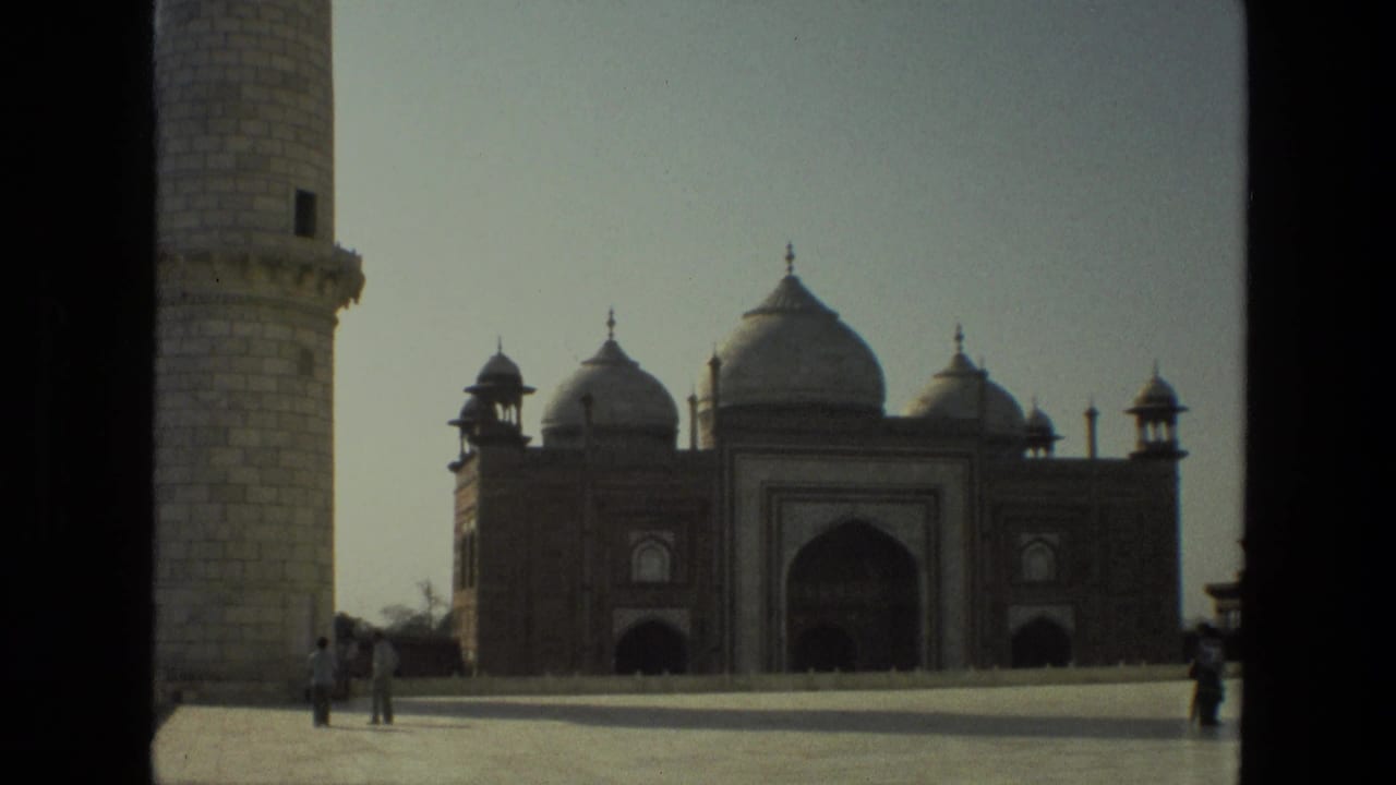 Wide view of the Taj Mahal complex framed by minaret edges and open plaza.