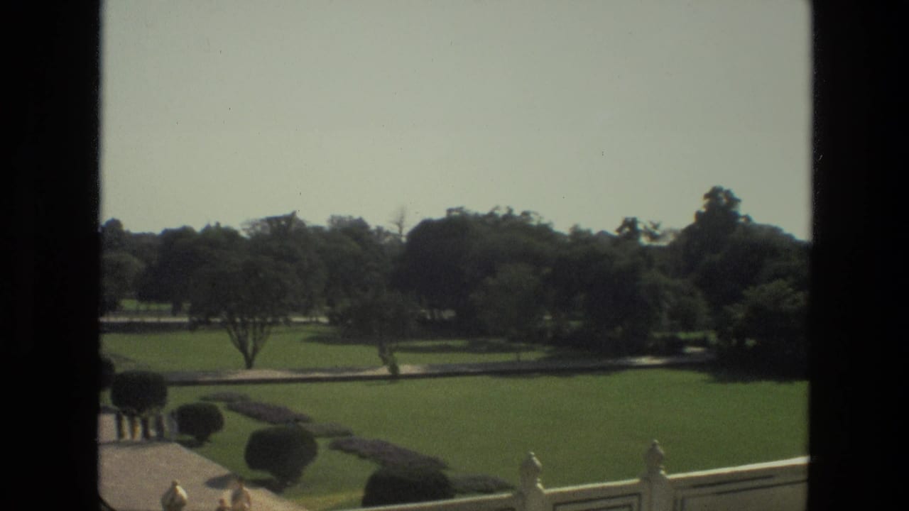 Formal gardens and pathways leading toward the Taj Mahal complex in the distance.
