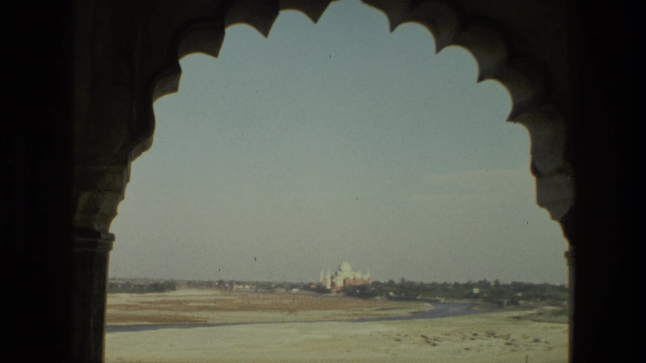 Dark scalloped temple arches frame a distant domed monument across open ground.