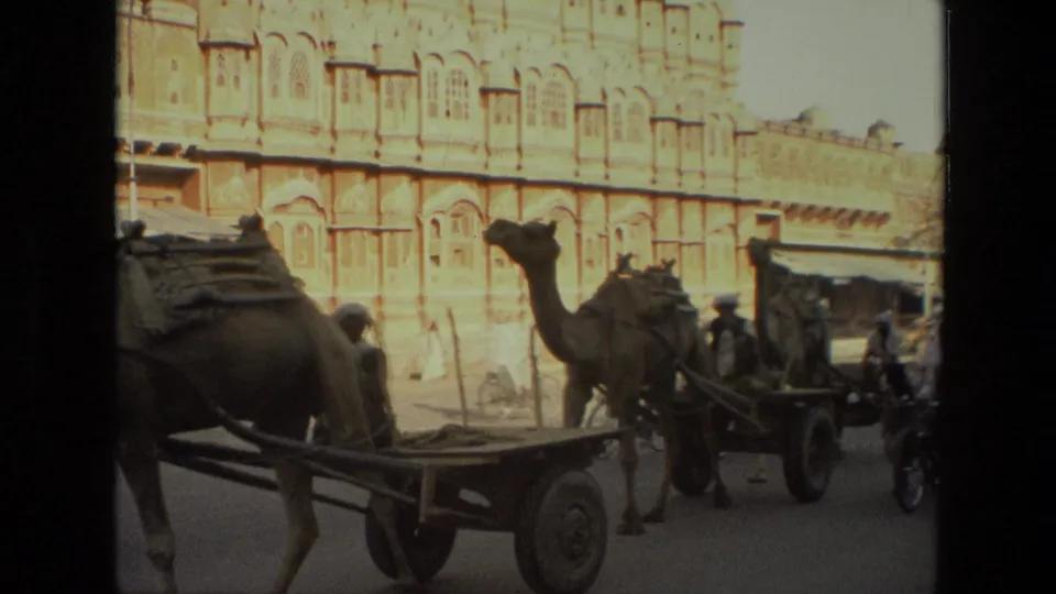Camel carts, pedestrians, and bicycles occupy a 1974 India street near the Hawa Mahal facade.