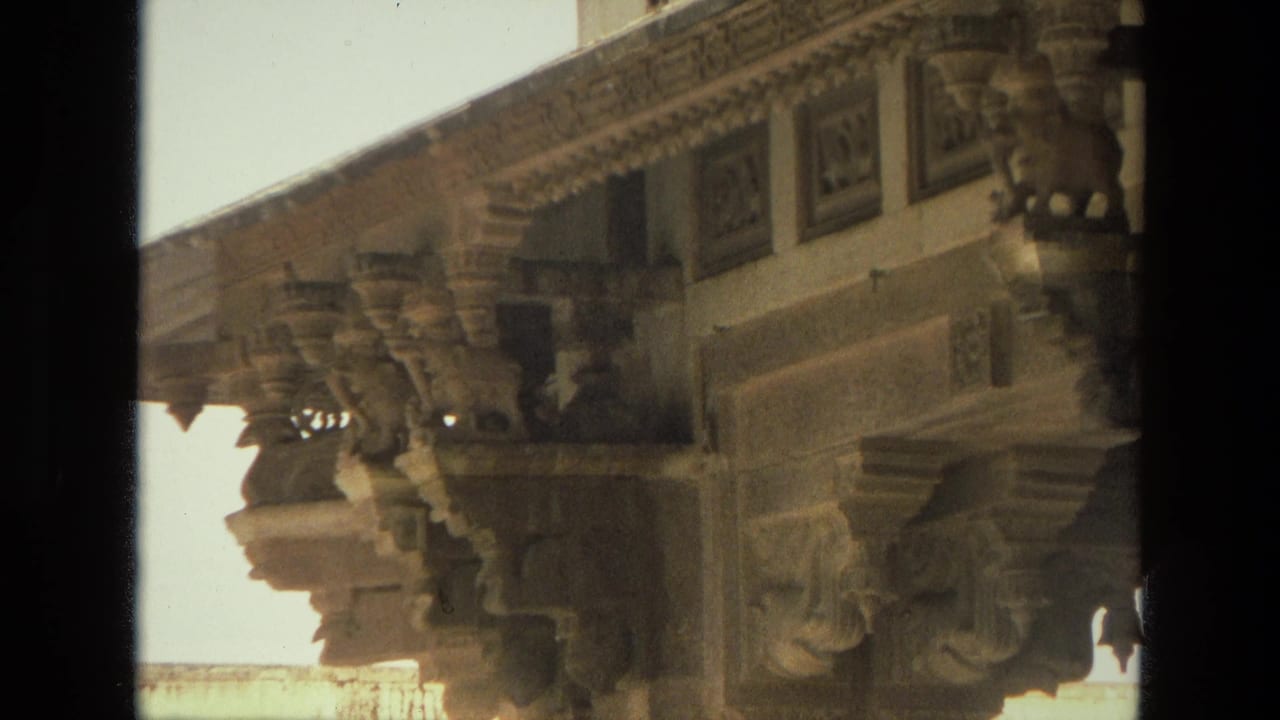 Ornate underside of a stone facade with sculpted supports and trim.