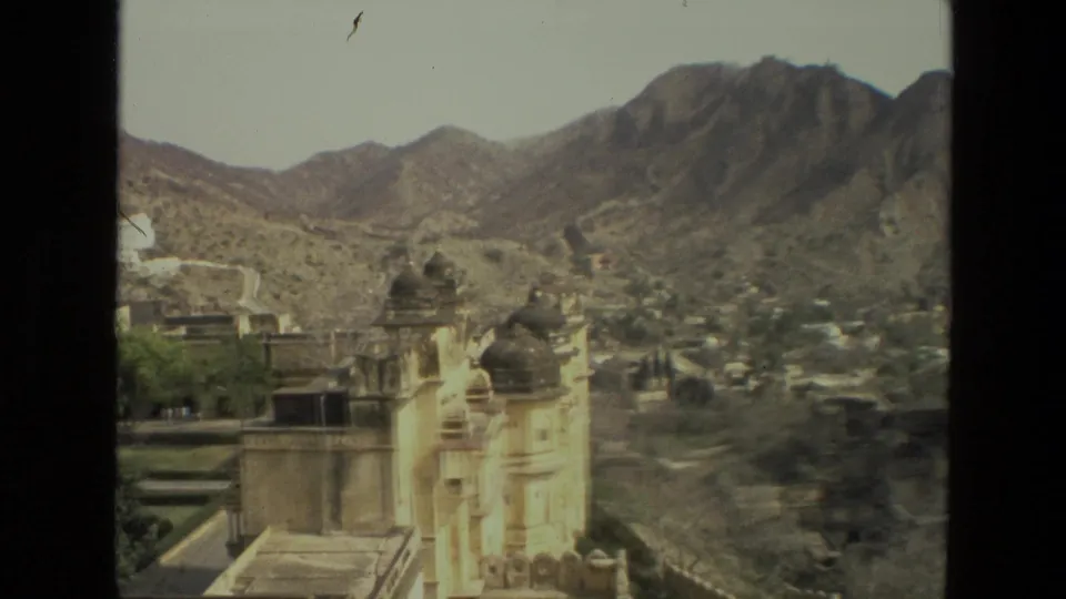 1974 India home-movie view of domed palace details, terraces, arid hills, and a distant settlement or road pattern.