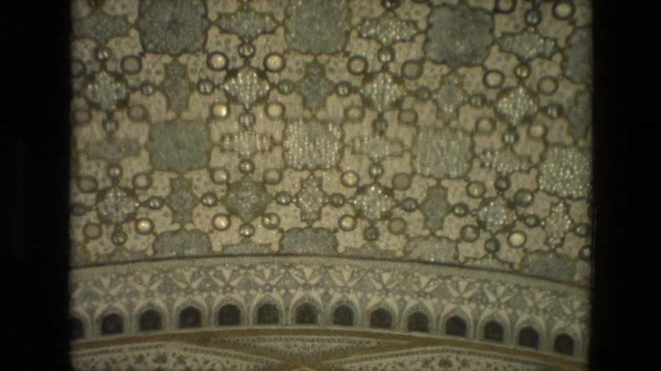 1974 India 8mm close-up of ornate geometric wall or ceiling decoration with reflective inlay and arched border detail.