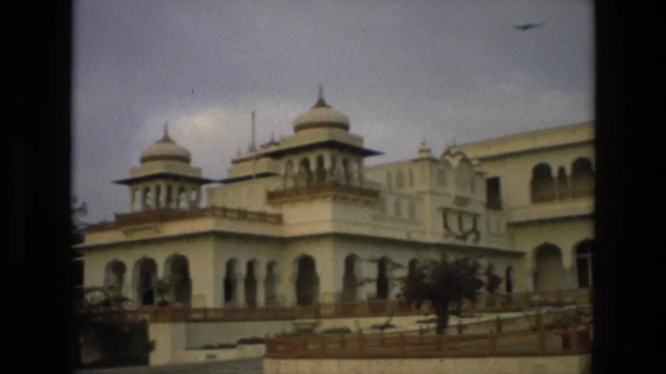 1974 India frame showing two domed turrets and arched openings on a cream palace-like exterior during the pan.