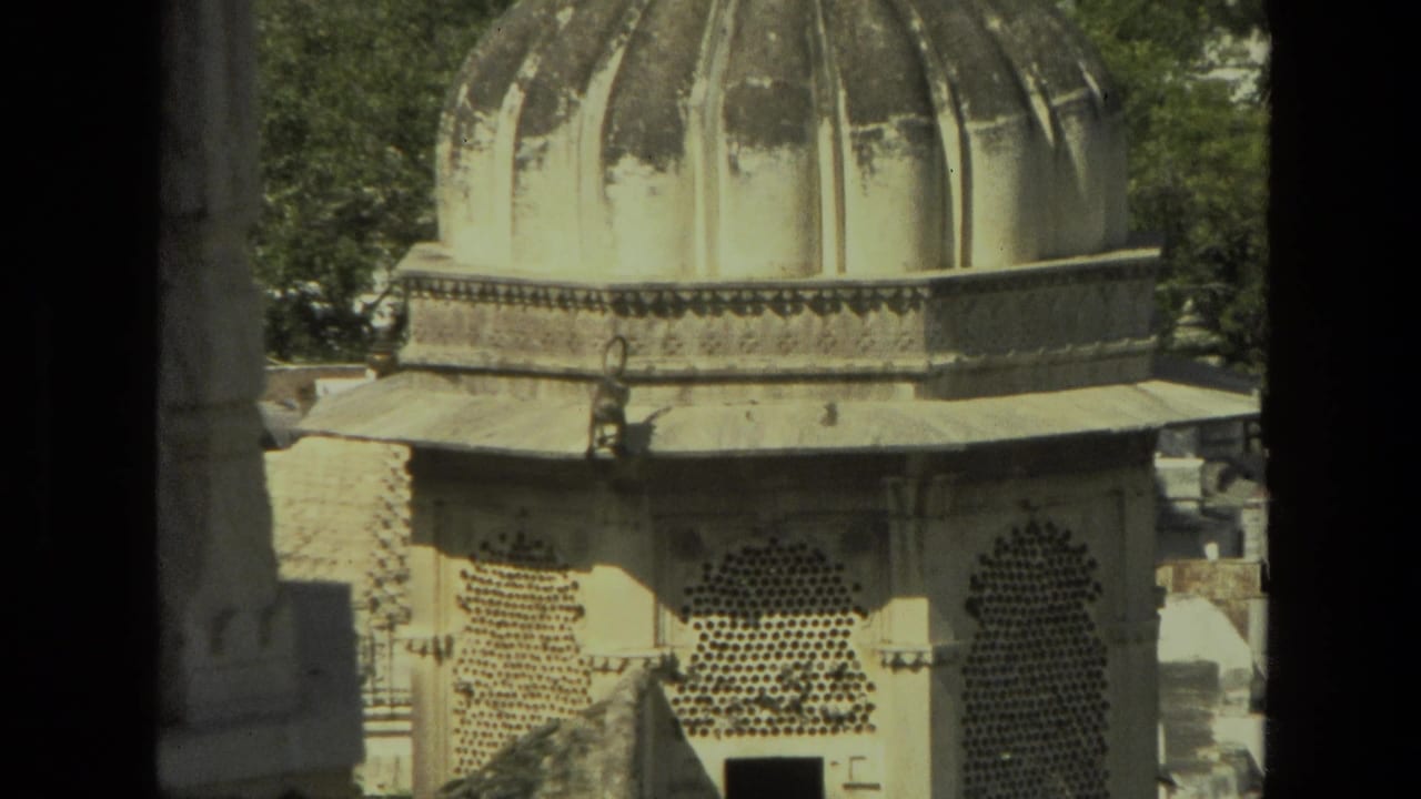 1974 India 8mm frame showing a domed religious structure with arched lattice windows and sunlit stonework.
