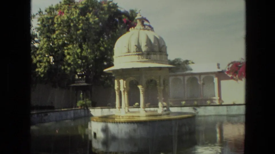 1974 8mm India footage showing a domed garden fountain pavilion before water is visible, with trees, walls, and a pool.