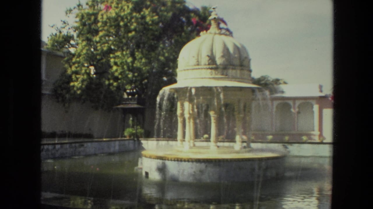 1974 8mm India footage showing water cascading from a domed pavilion fountain into a garden pool.