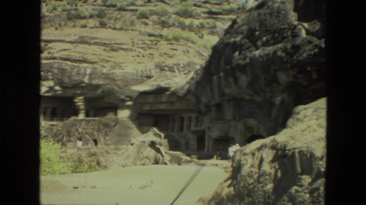 Rock-cut cave entrances and carved stone structures set into a mountainside.