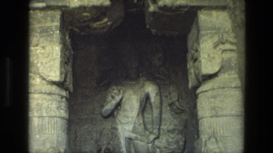 1974 India temple interior frame showing a standing carved figure and surrounding stone pillar details.