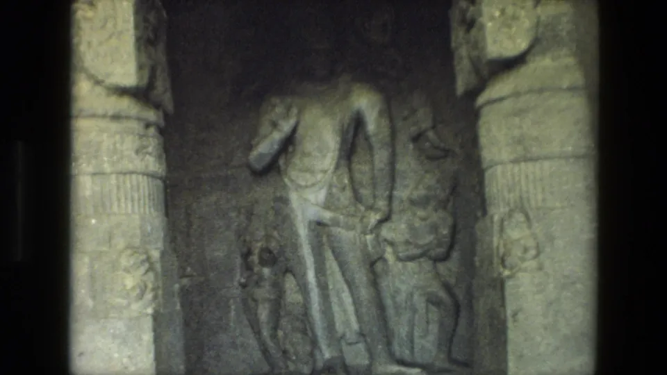 1974 8mm frame from India showing a close view of temple stone carving, with a figure and pillar detail.
