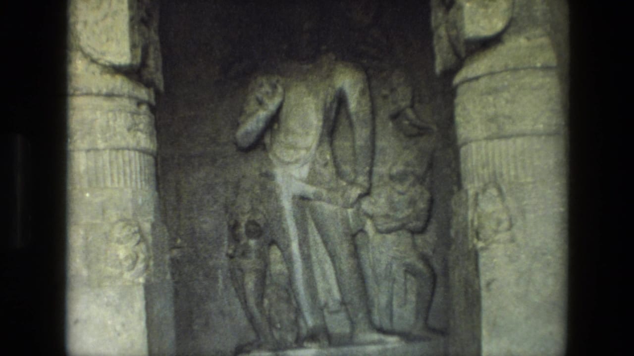 Stone relief carving of standing figures between column-like edges.