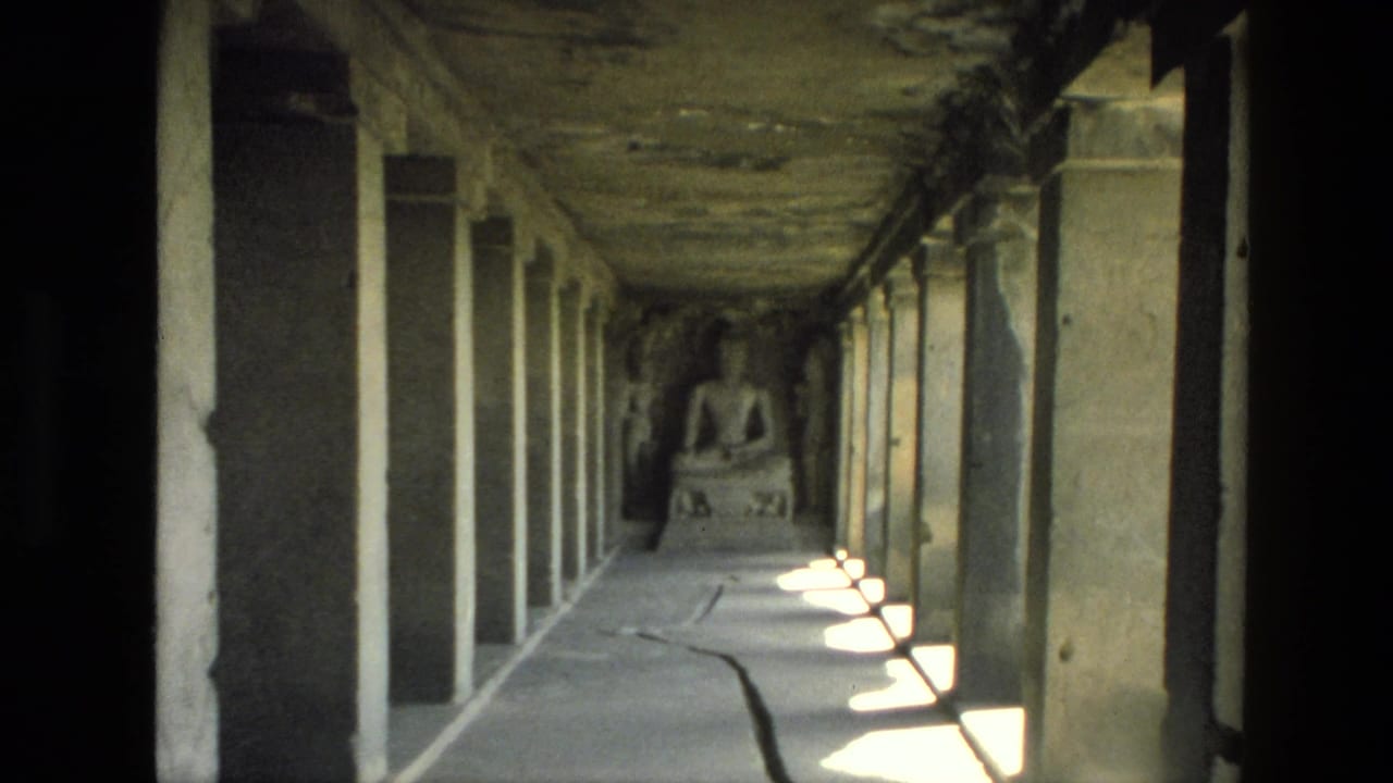 Dim stone temple corridor with pillars and a seated statue at the far end.
