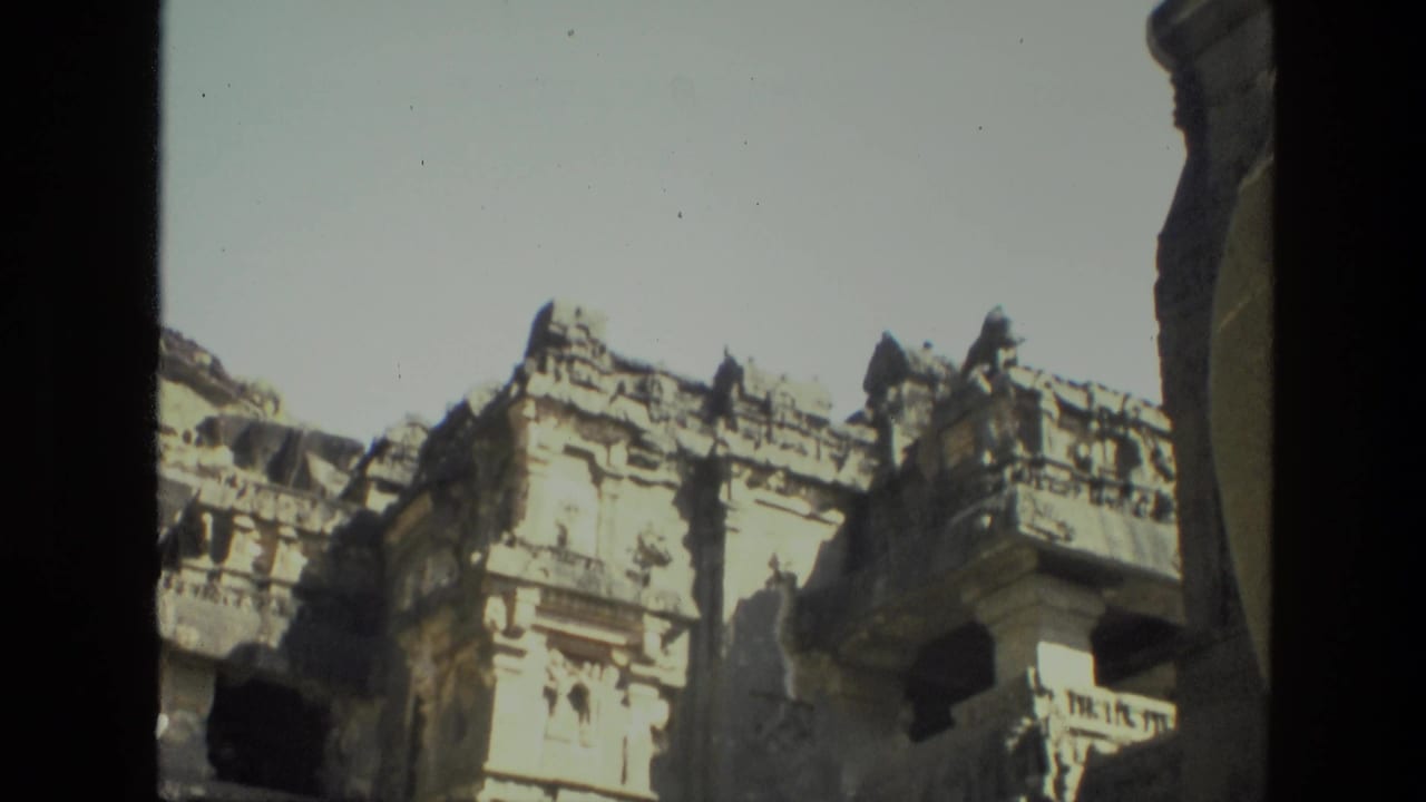 Carved stone facade built into a cliff face under bright sky.