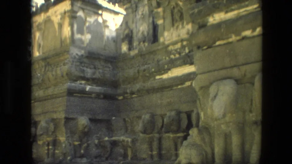 1974 India 8mm frame with a close visitor-shot view of worn sculpted stone forms and architectural reliefs.