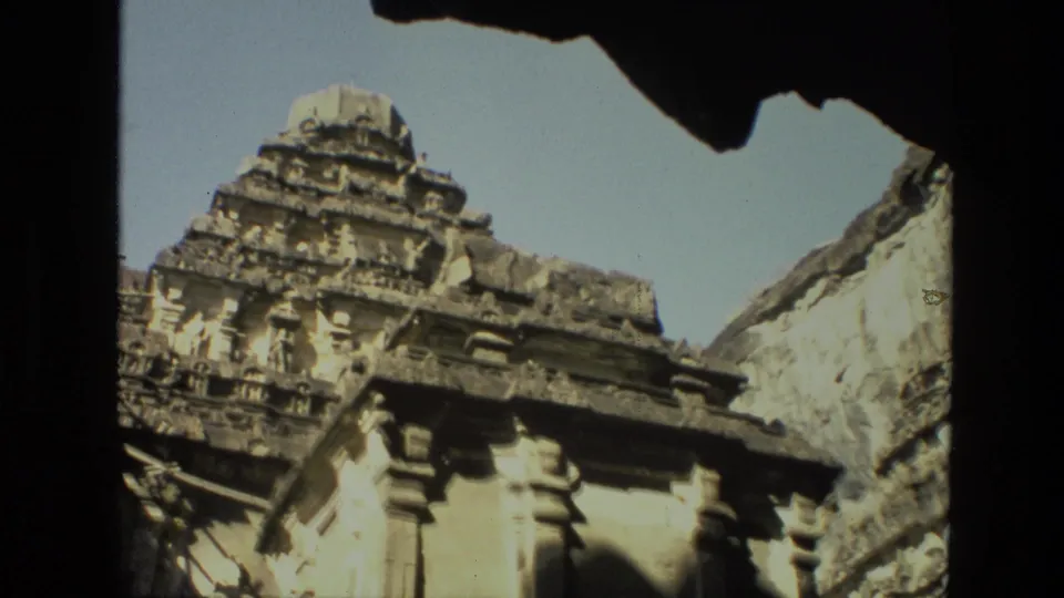 The final 1974 India frame shows a carved temple tower beside a weathered stone wall, with dark arch shadow above.