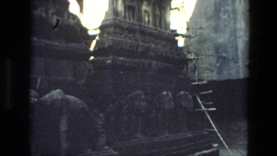 1974 8mm footage from India shows shadowed temple ruins with carved stonework, steps, scaffolding, and rough exposed masonry.