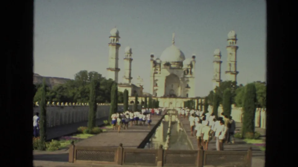1974 8mm frame showing visitors along the garden walkway and reflecting pool facing the Taj Mahal.