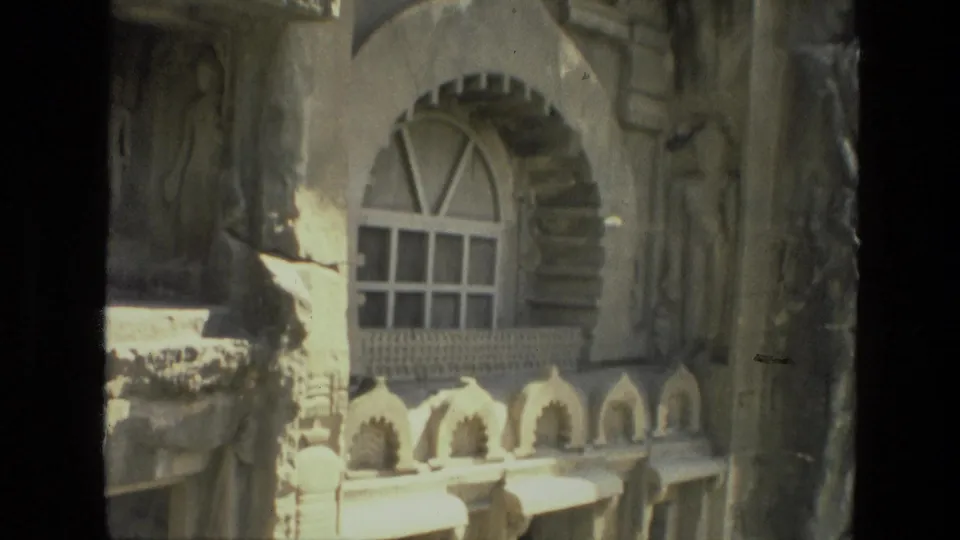 1974 India 8mm frame focused on an arched window, carved trim, and sculptural exterior details.