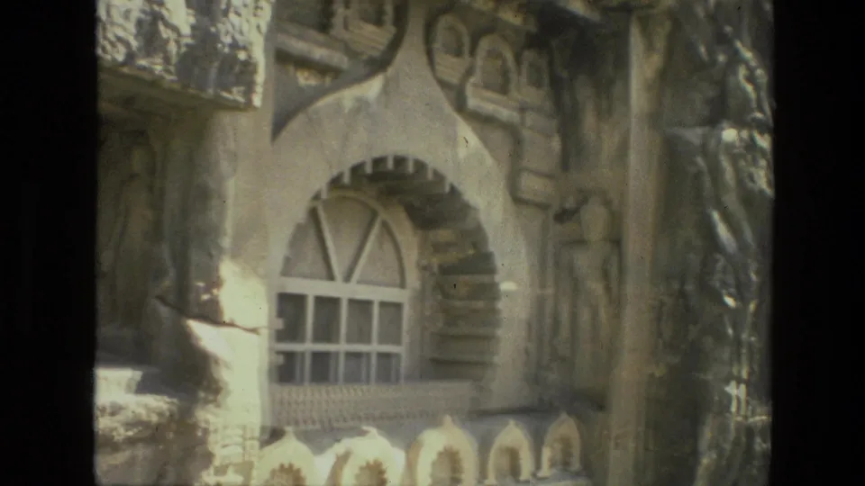 1974 India 8mm frame showing an ornate arched window, small decorative niches, and sculptural facade work.