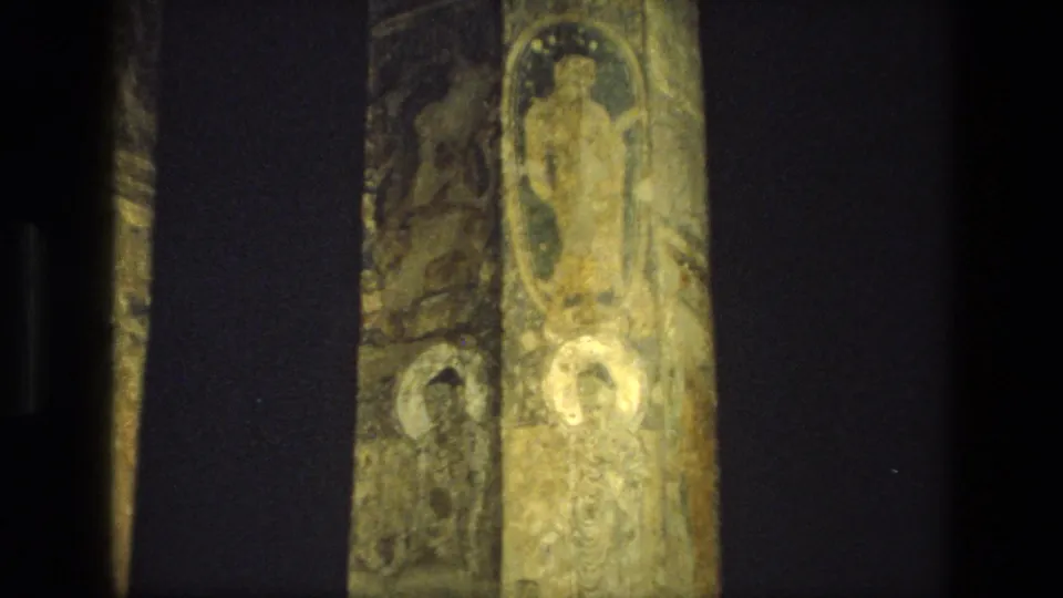 1974 8mm India footage appears to show painted pillars and religious murals inside a dim cave-temple interior.