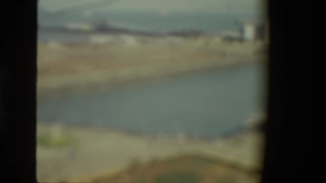 Soft, out-of-focus harbor and waterfront seen through a dark divided frame.