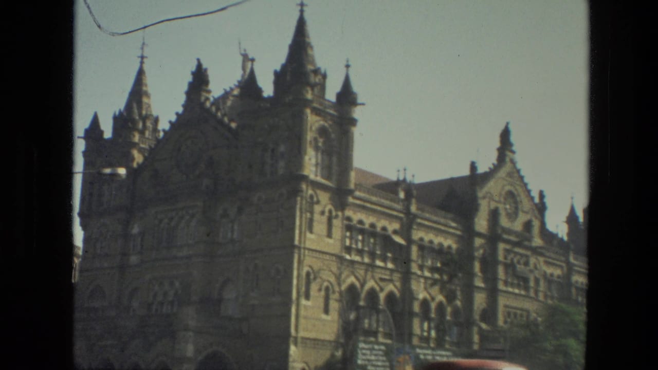1974 Mumbai landmark exterior showing the ornate station facade, tower details, arched windows, and a passing street view.
