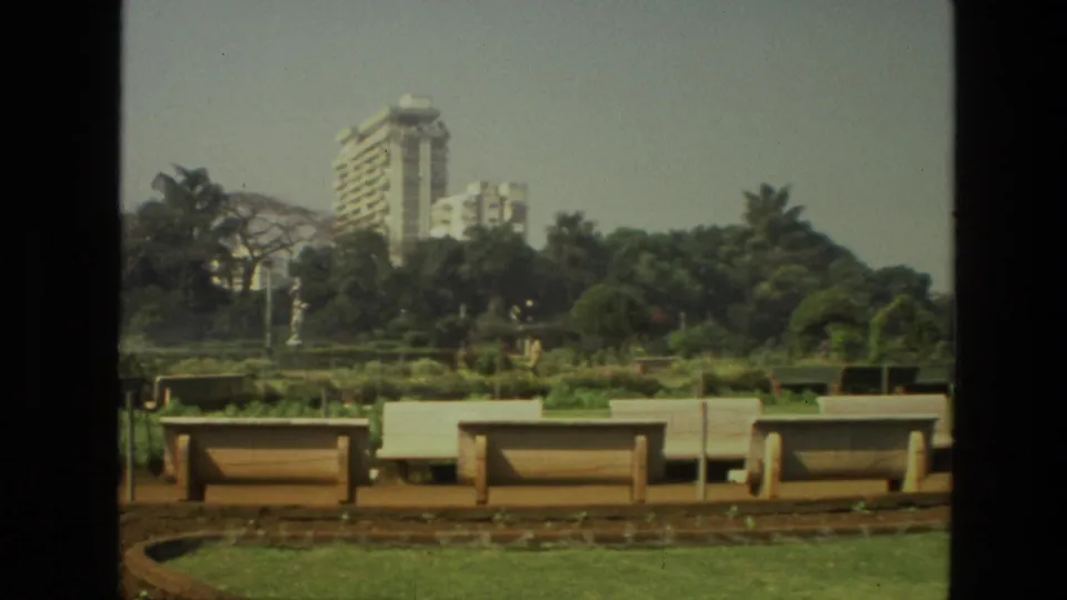 A 1974 India park scene shows benches, garden beds, trees, and high-rise buildings behind the landscaped grounds.