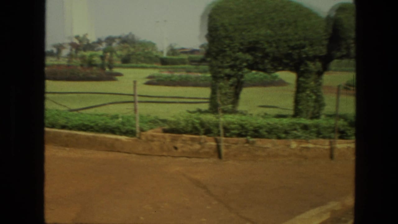 Large elephant-shaped topiary in a landscaped garden beside a dirt path.