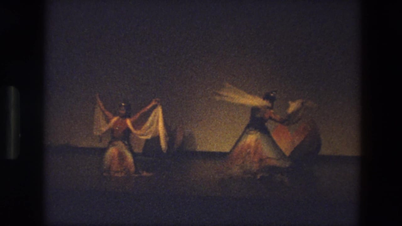 Three dancers spread across the stage, with scarves extended during a coordinated movement.