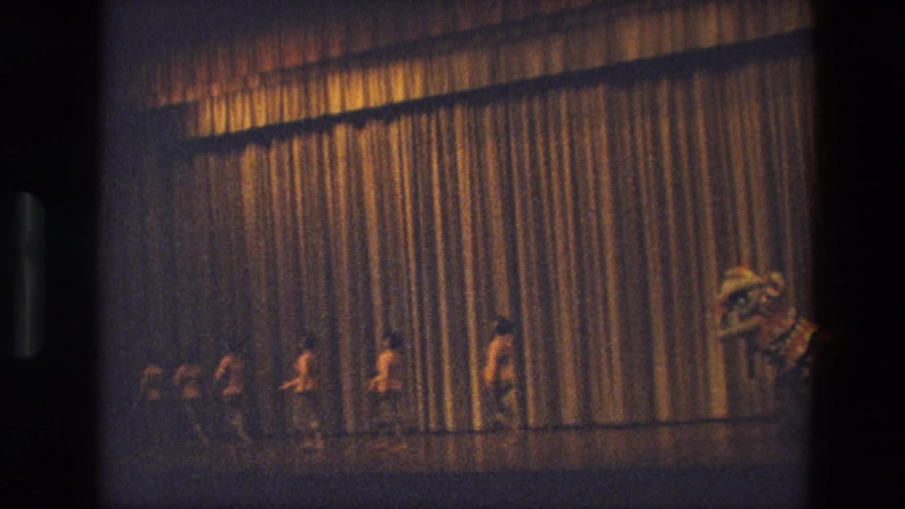 A stage scene in India shows several performers near a gold curtain, with a large animal or mythical-beast costume at the right edge.