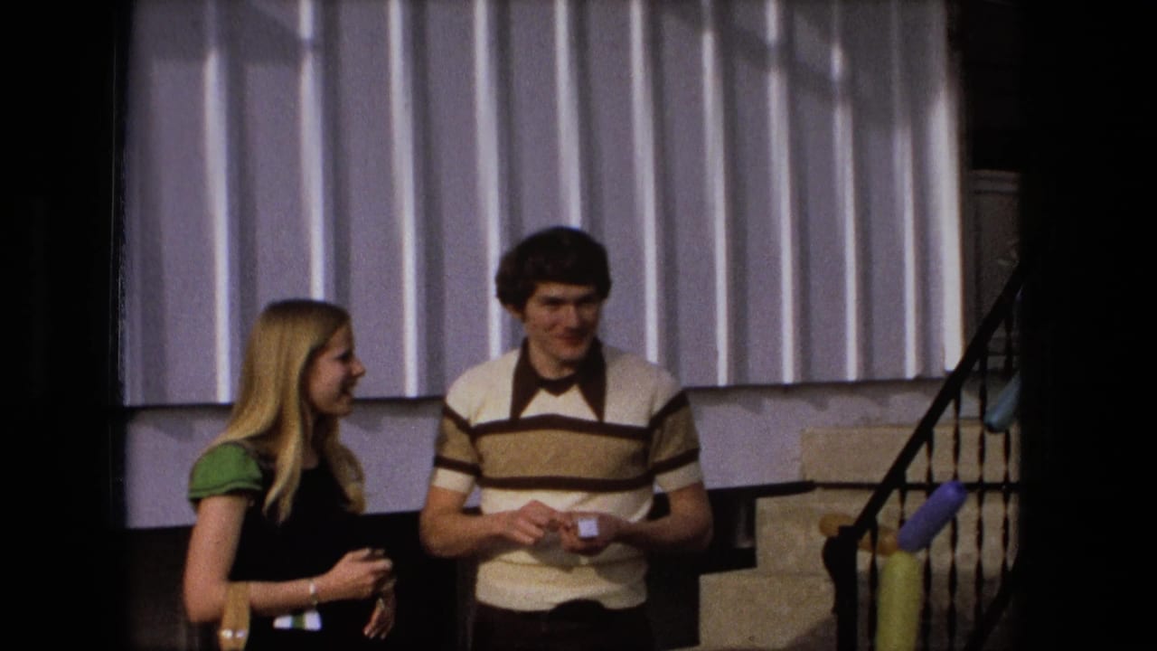 Young woman and young man talking near steps with balloons behind them.