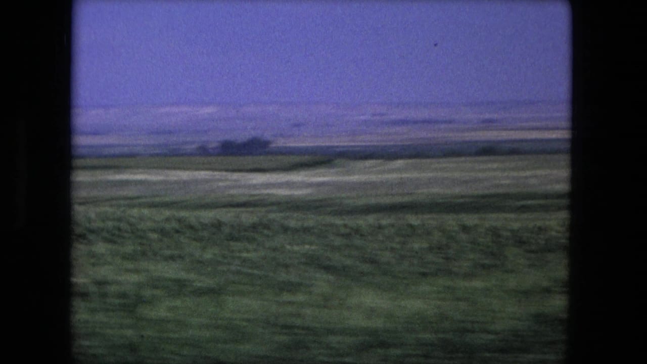 Fort Wayne-area field and horizon recorded from a moving vantage point in 1976 small-gauge travel footage.