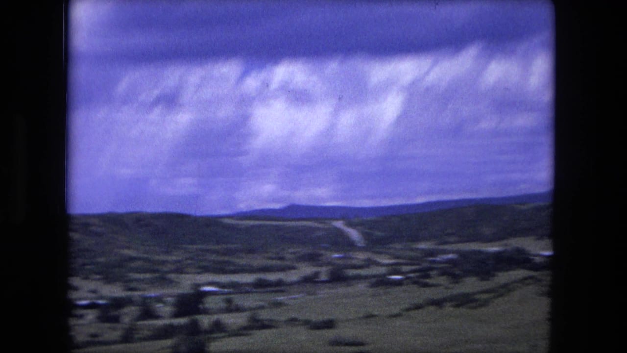 Rolling countryside and distant hills under a cloudy purple-blue sky.