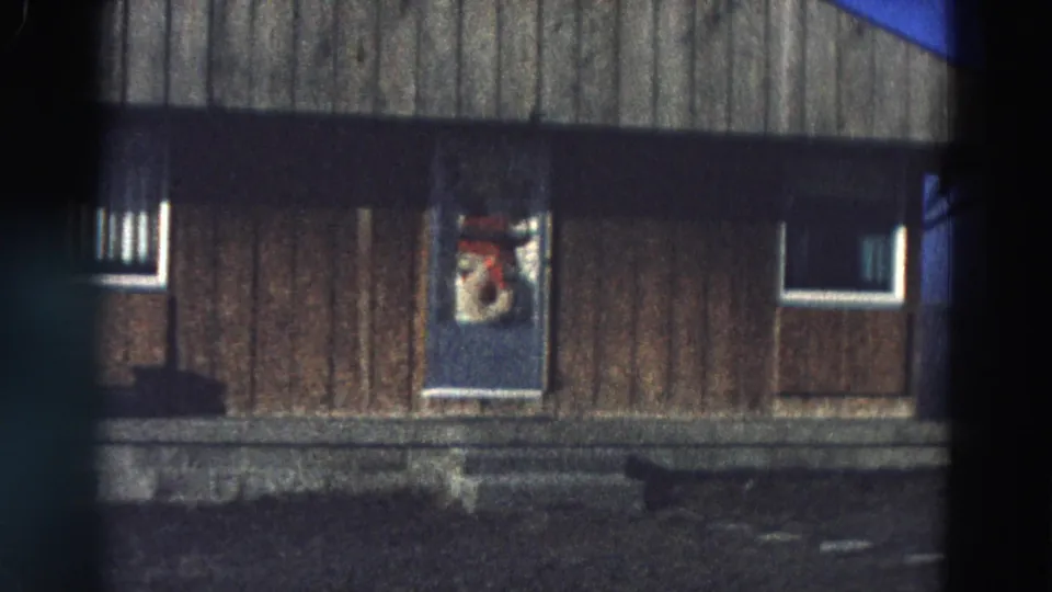 Diller, Nebraska exterior frame with a wood-sided wall, blue door, small windows, and visible 8mm frame borders.