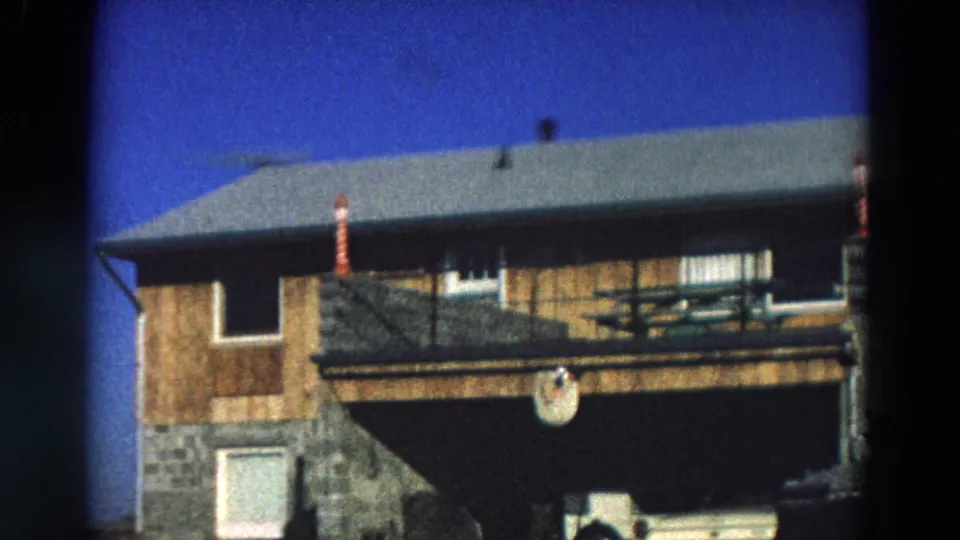 1968 Diller, Nebraska frame of the house front with porch railing, upper windows, striped posts, and shaded entry area.