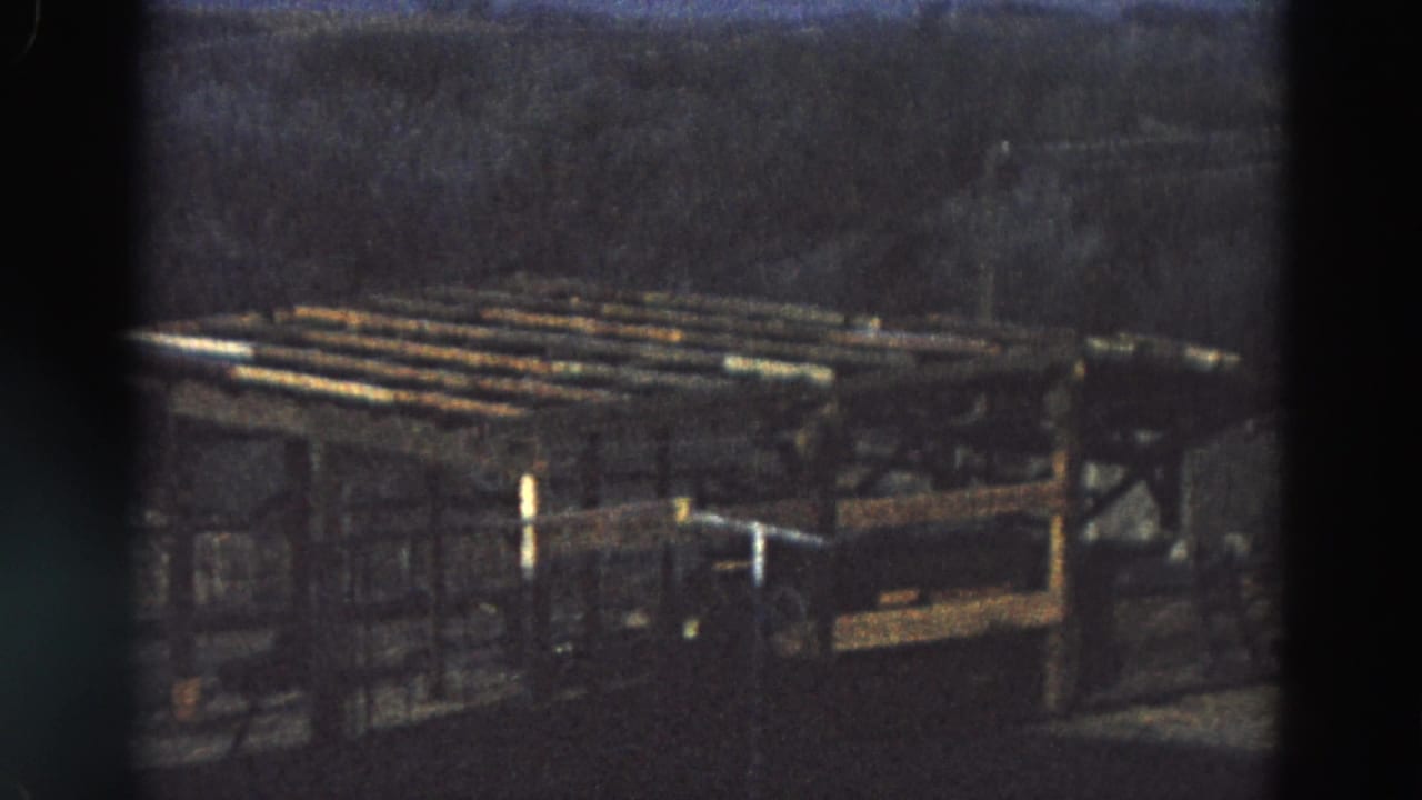 Dim outdoor industrial-looking rack or platform in low light.