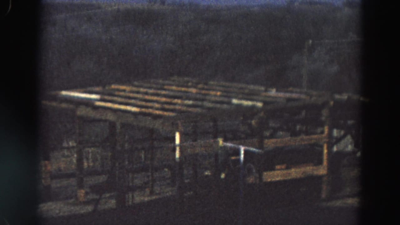 Dark structure with parallel rails and supports outdoors.