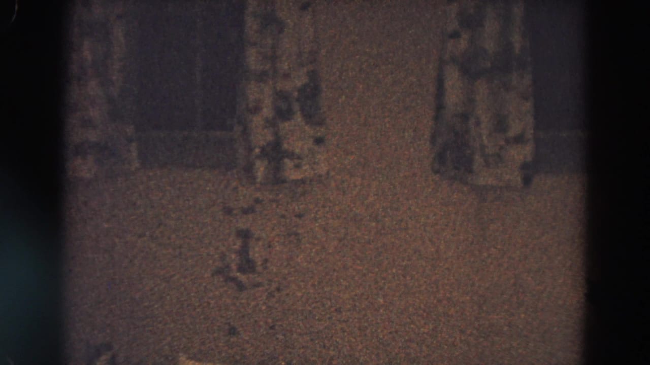 Dim wall display with small pictures partly obscured by dark film edges.