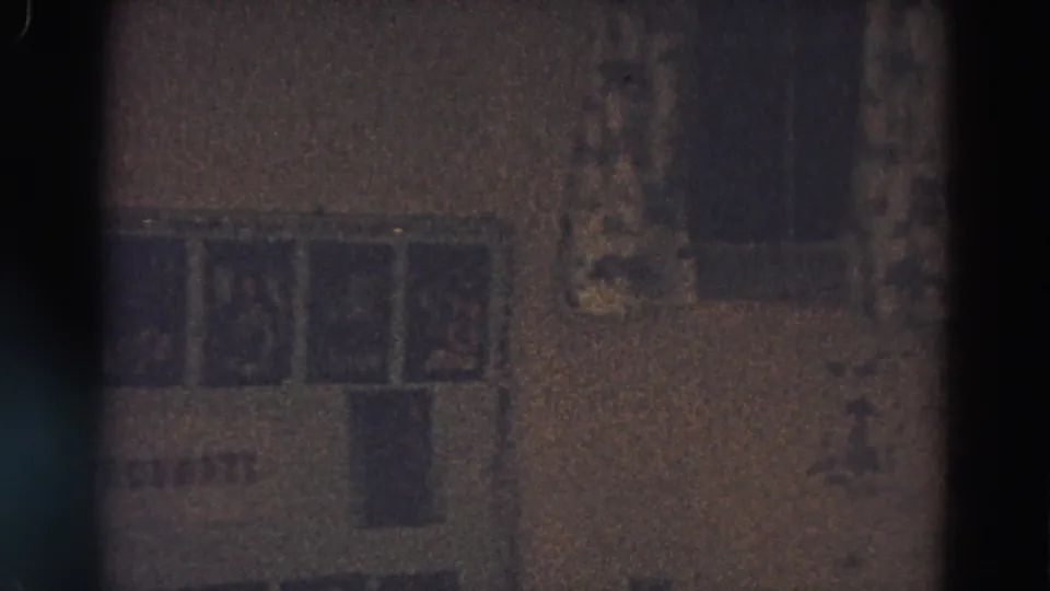 A grainy 8mm view of a holiday wall display in Diller, Nebraska, with small pictures and a darker rectangular area below.