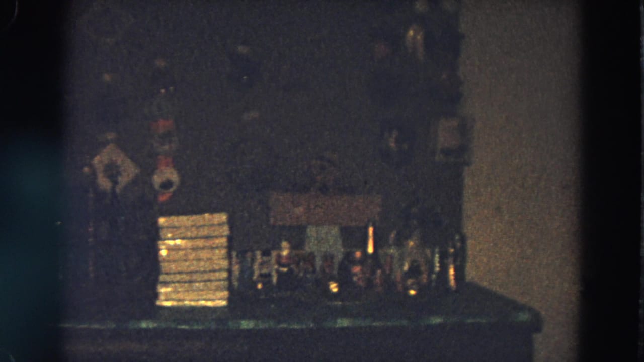 Makeshift bar counter with bottles, glasses, and stacked items against a wall.