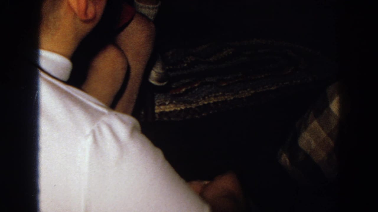 Person in a white collared shirt seen from behind in a dark crowded interior.