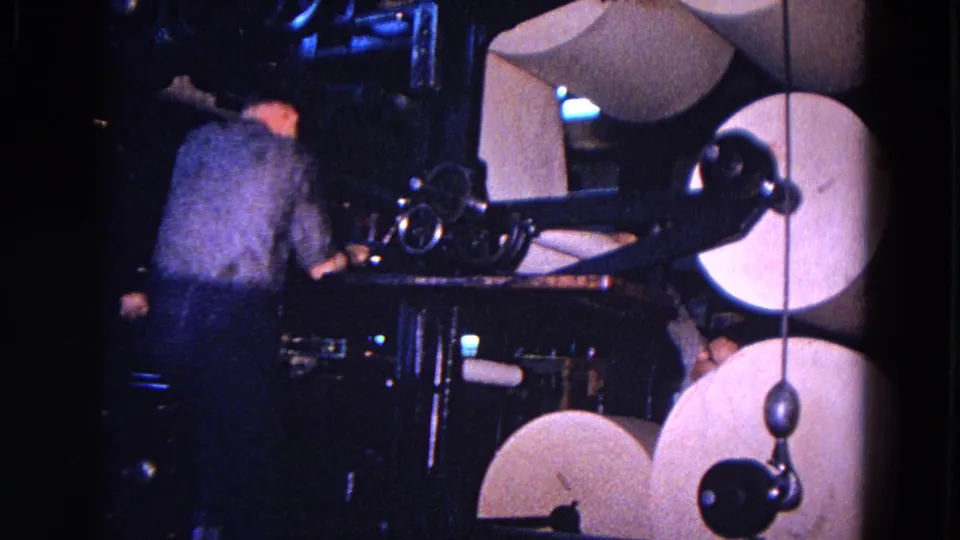 The 1967 Trenton footage shows a worker bending toward paper-handling machinery with large rolls close by.