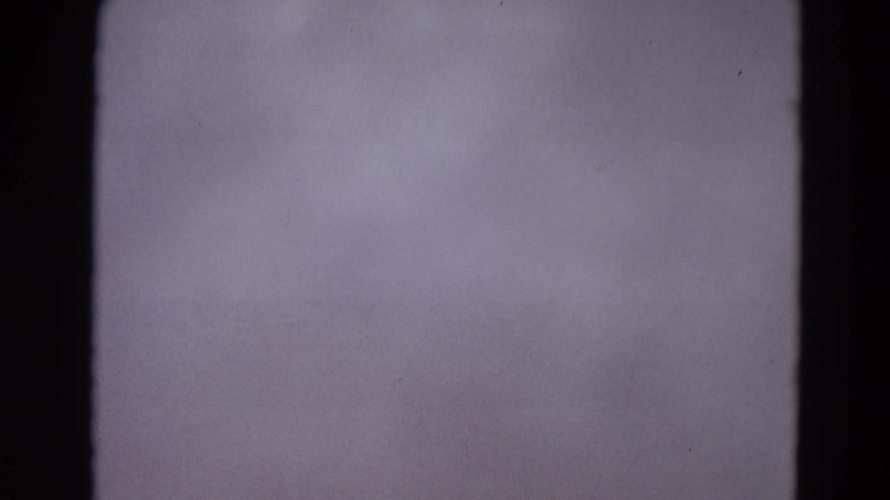Mostly blank purple-gray film frame with dark 8mm border and visible grain.