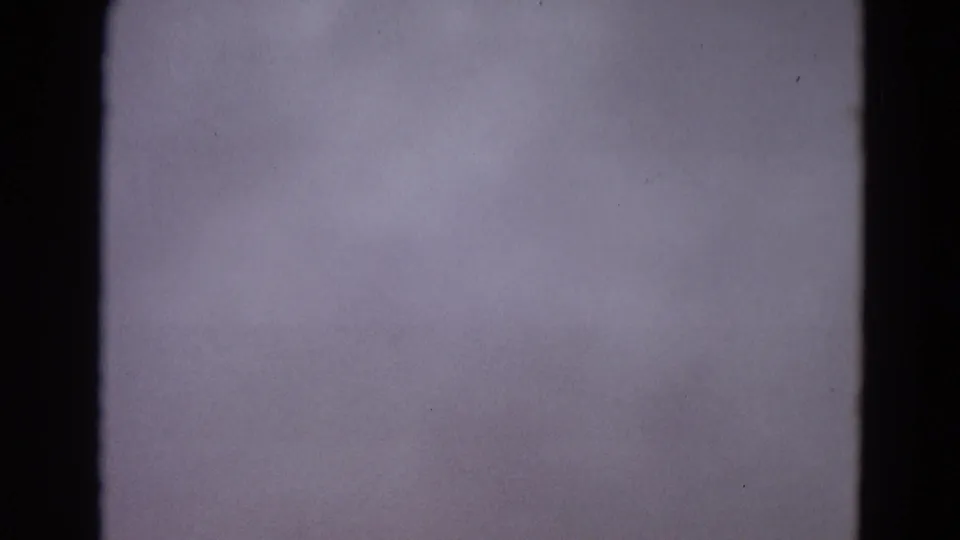 Blank-looking 8mm frame from the 1967 Yellowstone clip, showing purple-gray exposure, dark gate edges, and film specks.