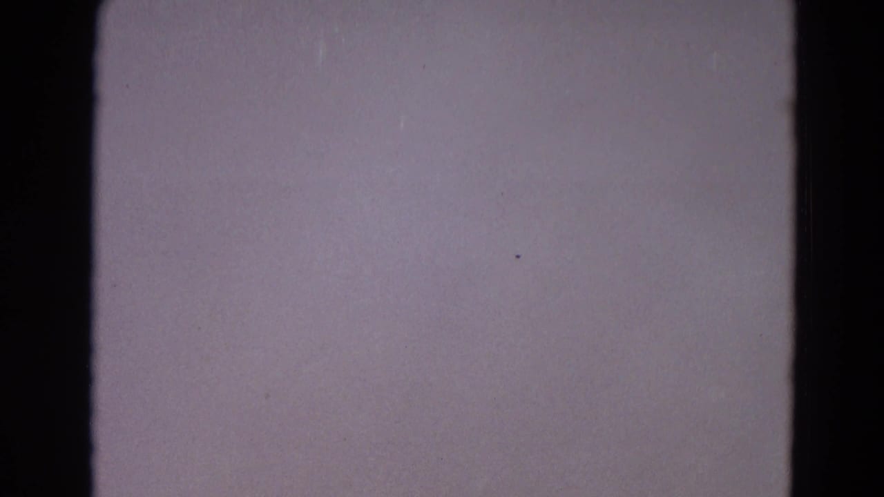 Mostly blank purple-gray film frame with dark vertical frame edge and grain.