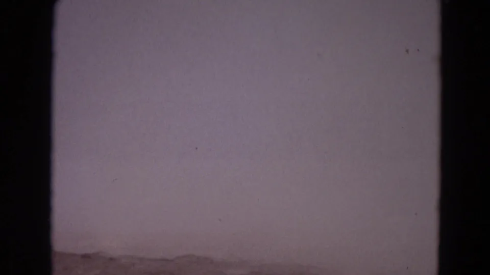 Underexposed or blank-looking 8mm frame within the 1967 Yellowstone sequence, showing film grain, dust, and dark frame edges.