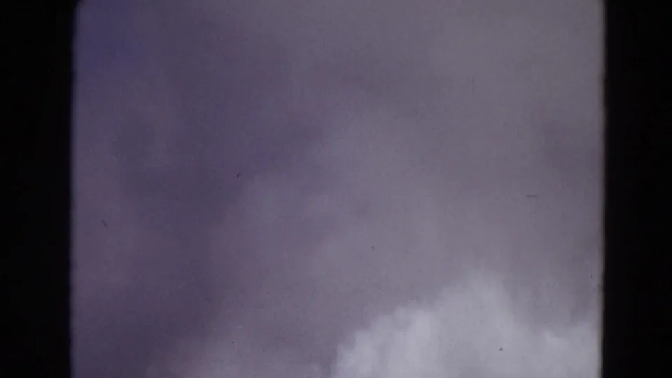 1967 Yellowstone 8mm frame with a close view of pale steam or spray rising into a muted sky.